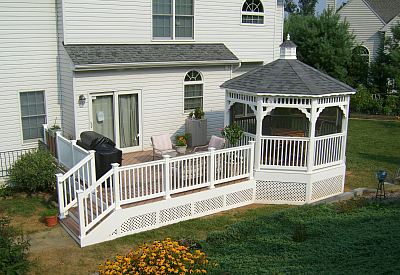 Photo of  a Custom Trex patio deck that includes screened-in gazebo, white railings
and skirt and composite decking